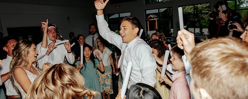 A crowd of smiling, dancing friends and family at a wedding.
